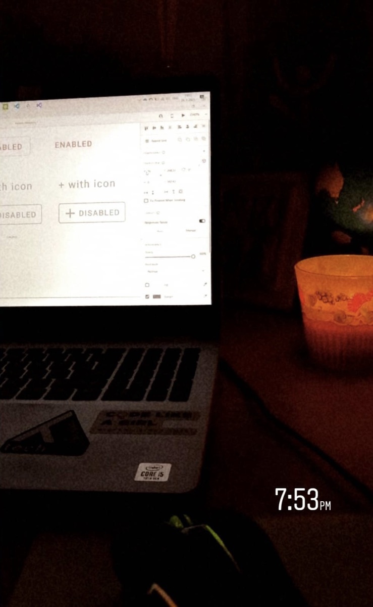 Late-evening design work on a laptop by candlelight, button states open in the design tool